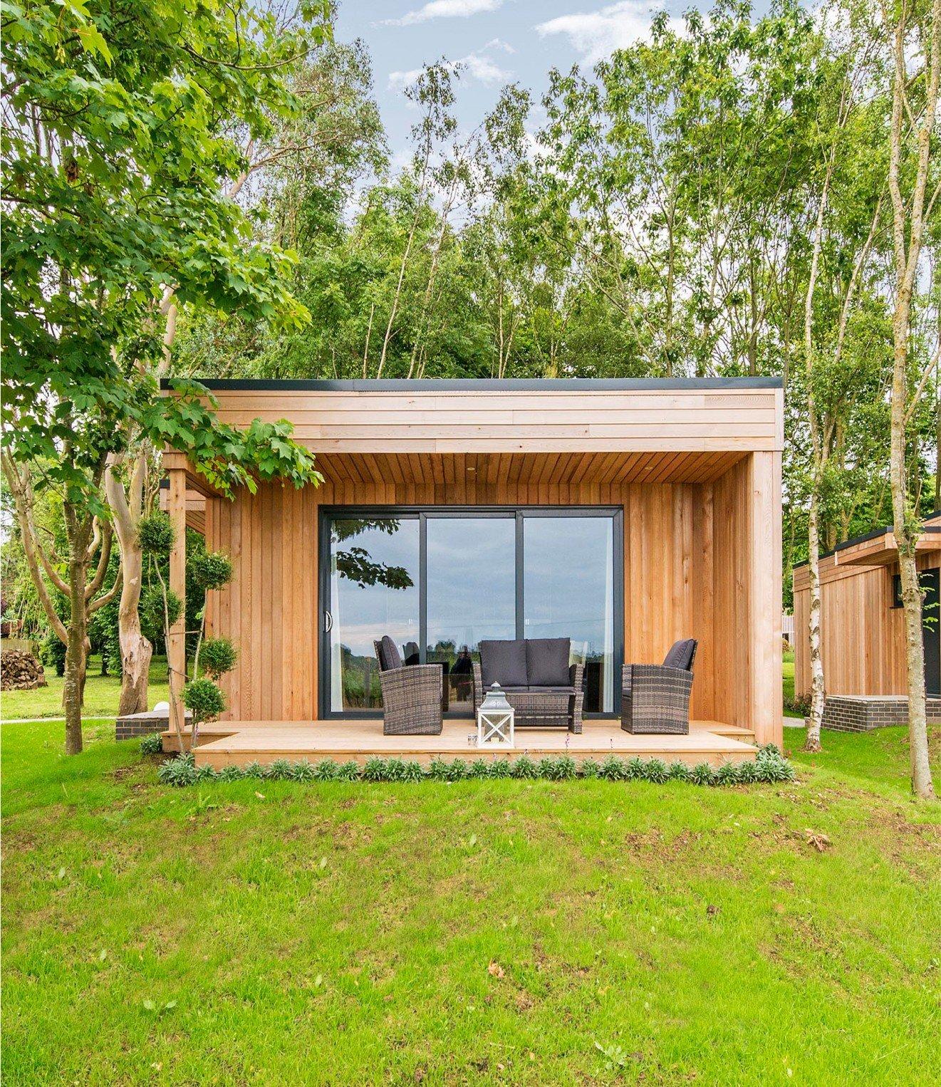 a small wooden cabin with a patio and furniture